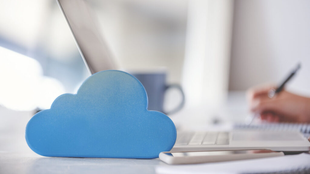 Woman using a laptop with cloud icon on working at home.