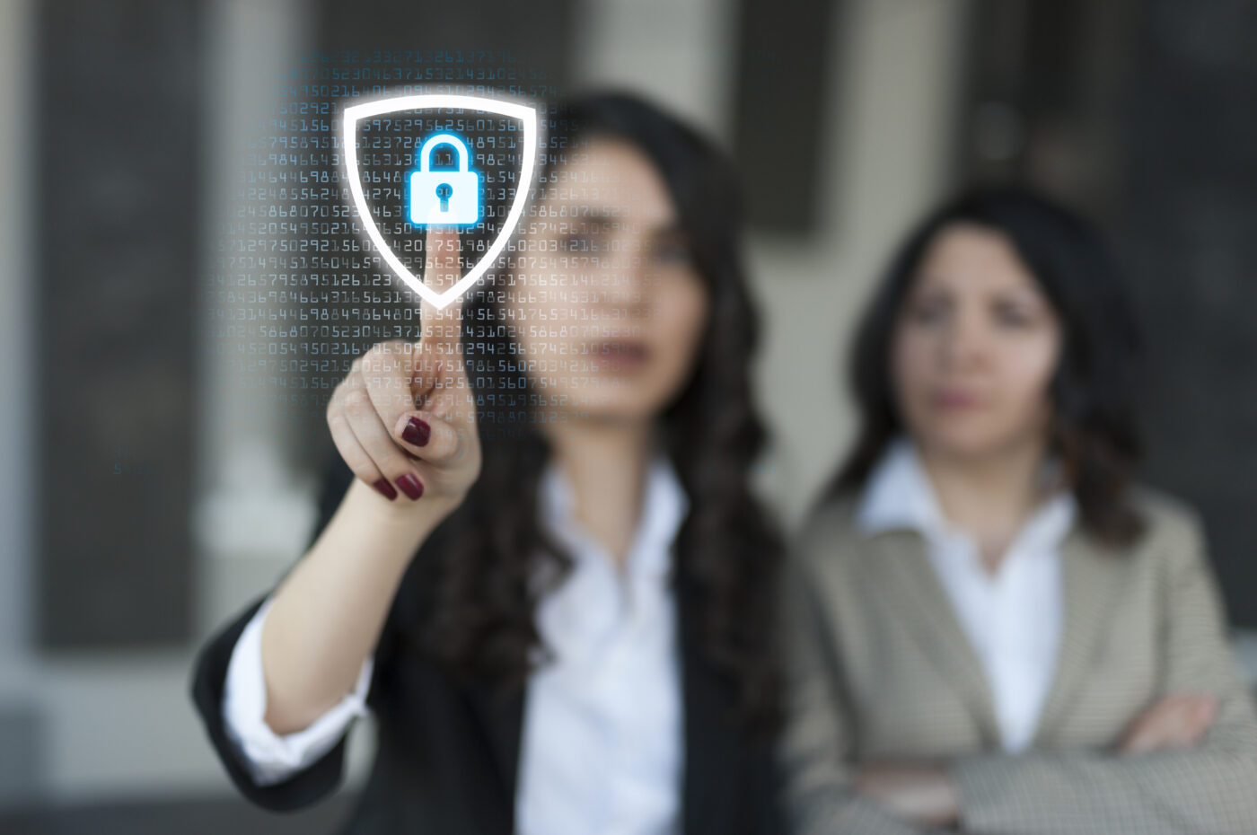 A woman points at a digital security lock on transparent interface