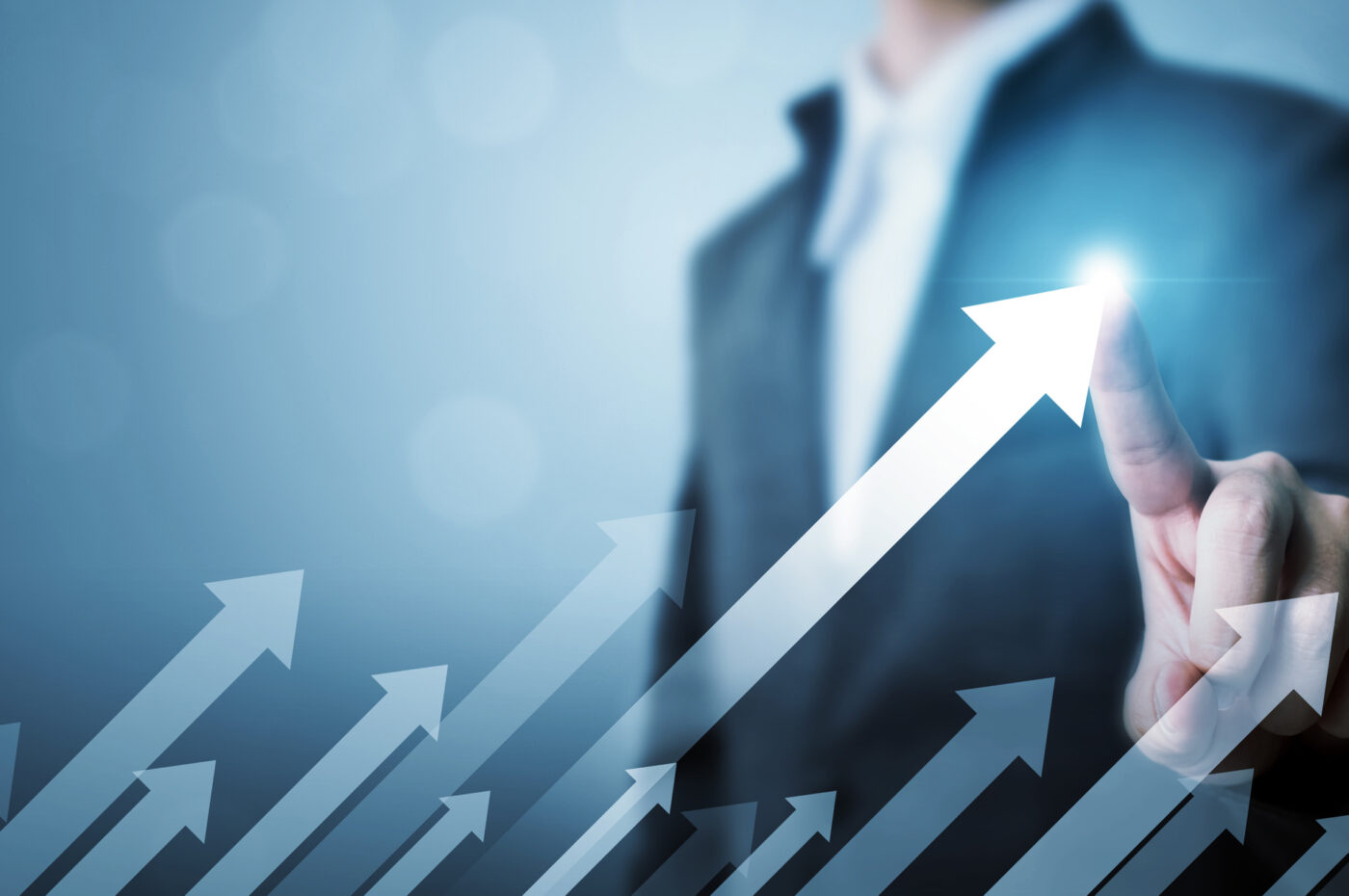 Businessperson pointing at glowing upward arrows, symbolizing growth and progress
