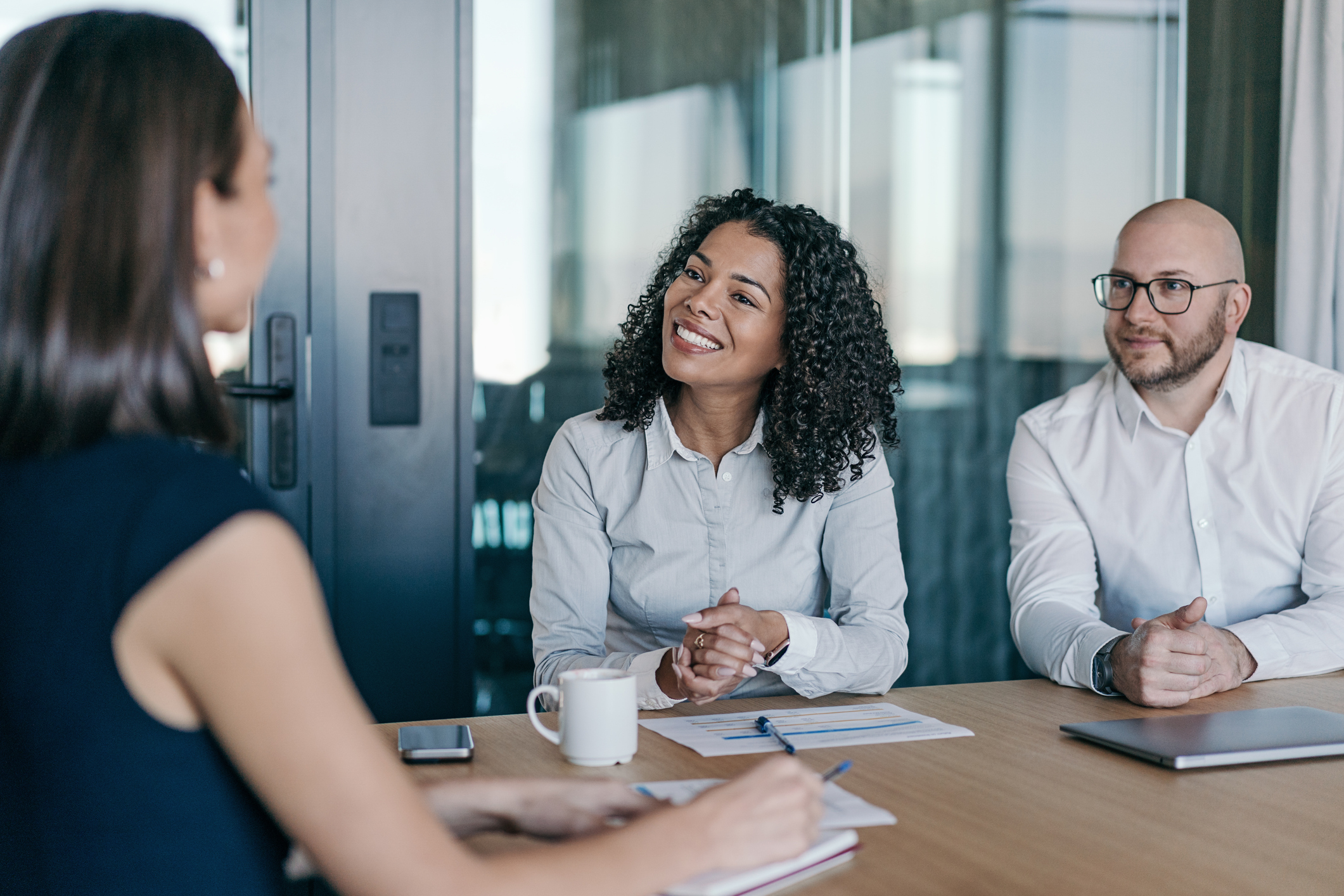 Three colleagues discussing in a modern conference room