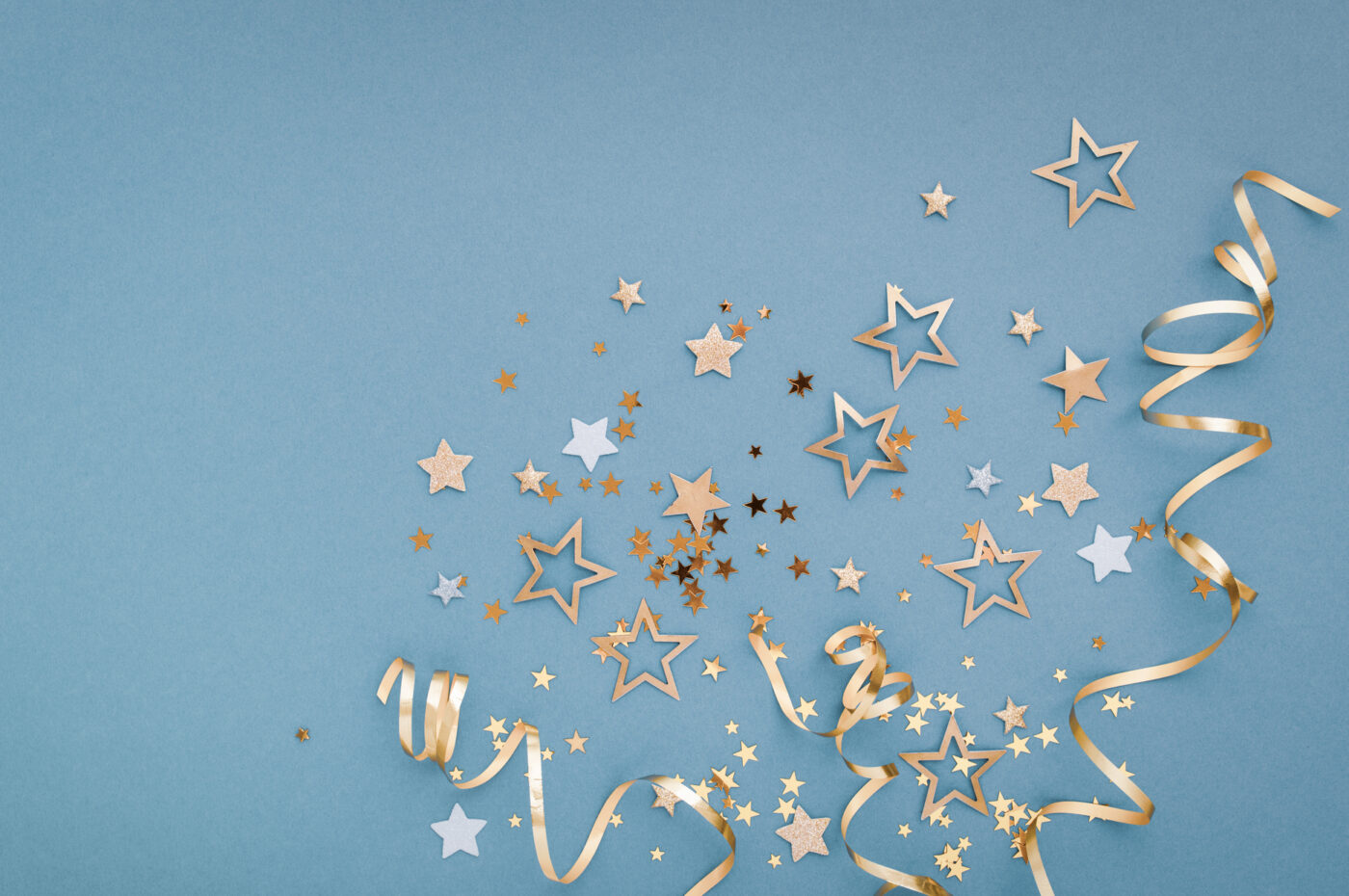 Gold and silver stars with ribbons on a blue background