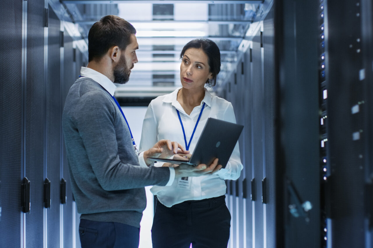 Two people discussing work in a server room